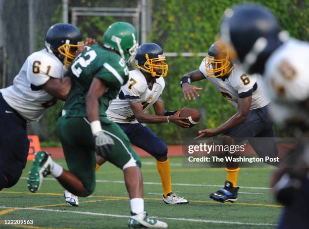 August 26: Perry quarterback Jihad Khabir hands the ball off to Adrian Diggs during the game at Wilson High School on Friday, August 26, 2011. Wilson...