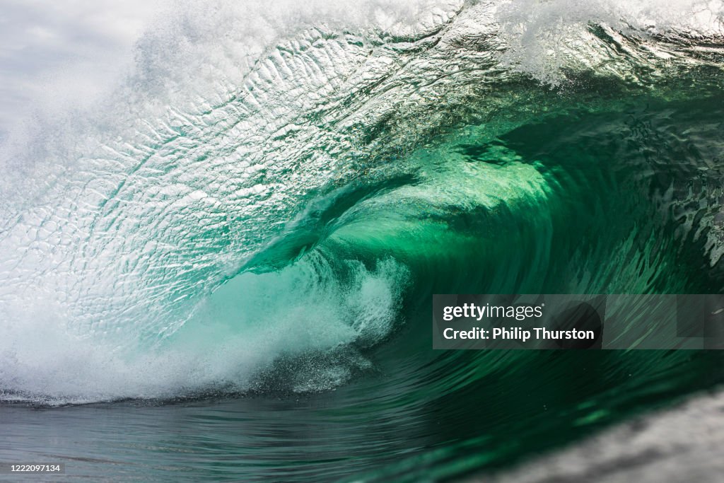 Emerald green wave breaking in the ocean