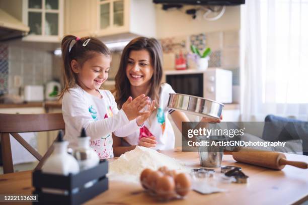 mother and daughter cooking together at home. - mother daughter baking stock pictures, royalty-free photos & images