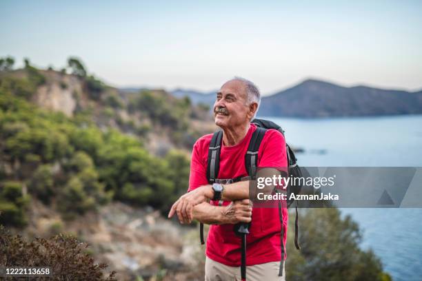 relaxed spanish senior male backpacker on coastal trail - old person with walking stick outside standing stock pictures, royalty-free photos & images
