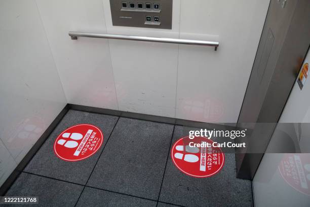 Social distancing markers are pictured on the floor of an elevator on June 23, 2020 in Tokyo, Japan. Restrictions on businesses in Tokyo were fully...