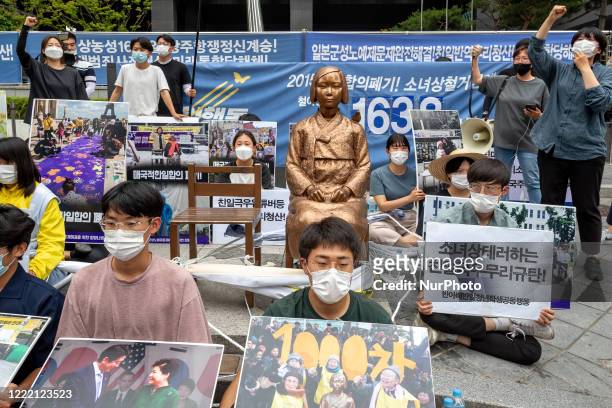 Members of The Anti-Abe Anti-Japanese Youth Student Joint Action , tie each other's bodies with a rope and sit down and hold banners written as...