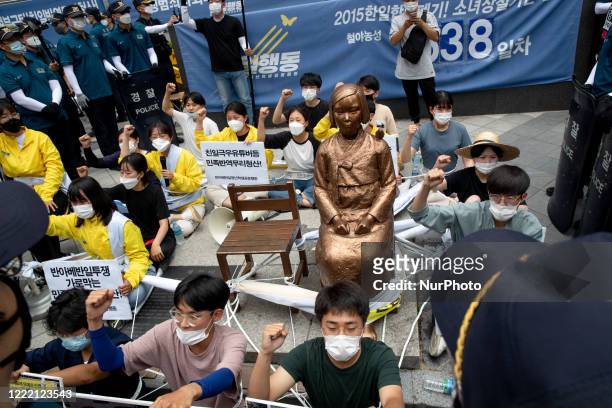 Members of The Anti-Abe Anti-Japanese Youth Student Joint Action , tie each other's bodies with a rope and sit down and hold banners written as...