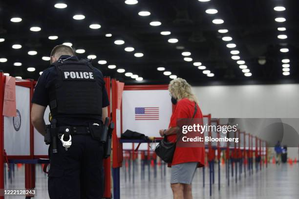 Louisville Metro Police Department officer casts a ballot at a polling location in Louisville, Kentucky, U.S., on Tuesday, June 23, 2020. Voters face...