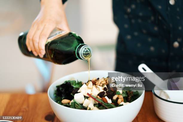 homemade gourmet food: fresh green salad with mozzarella, mixed nuts and dry fruits - salad bowl stock pictures, royalty-free photos & images