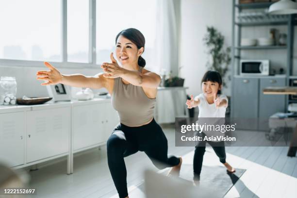 jeune mère asiatique joyeuse et petite fille exerçant et pratiquant le yoga ensemble à la maison - family yoga photos et images de collection