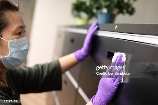 woman wearing gloves cleaning locker - office cleaning stock pictures, royalty-free photos & images