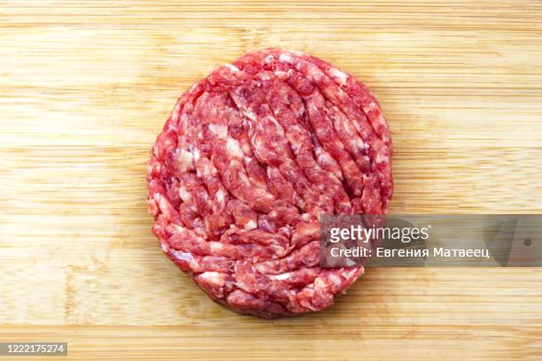 raw beef burger cooking on natural bamboo wooden cutting board background close-up. top view. - hamburger photos et images de collection