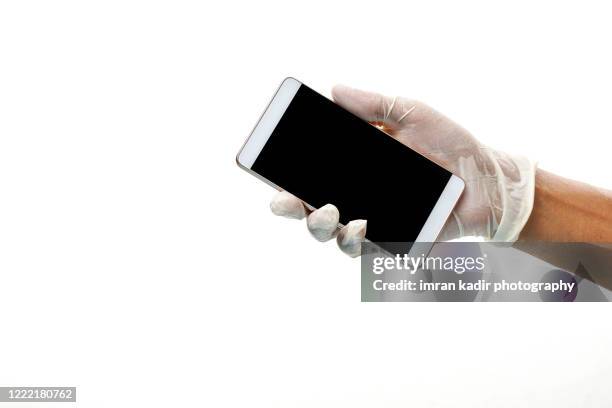 hand using late glove holding phone on blank screen. white background - rubber gloves stockfoto's en -beelden