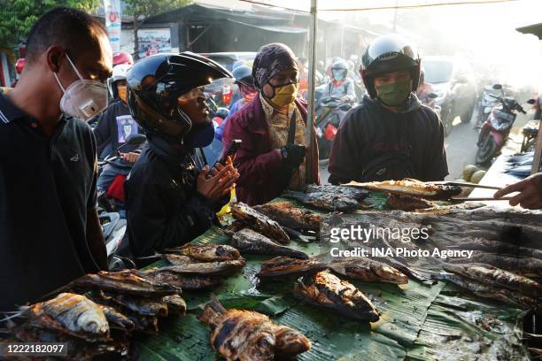 Indonesian Muslims buy smoked grilled fish in a local market in Makassar during the fasting month of Ramadan amid coronavirus threats.