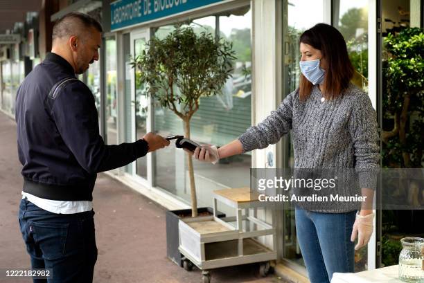 Client is seen picking up his Lily of the Valley after ordering online in celebration of Labor Day during the Coronavirus pandemic on May 01, 2020 in...