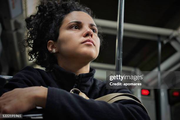 pensive hispanic young woman traveling in the subway - introspection stock pictures, royalty-free photos & images