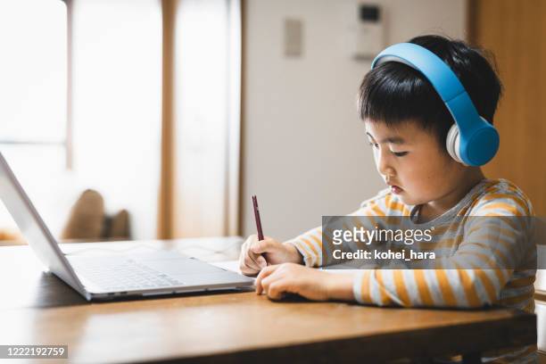 jongen die hoofdtelefoon draagt die een e-het leren cursus met laptop neemt - social distancing classroom stockfoto's en -beelden