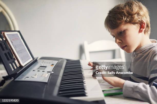 child learning to play the keyboard - instrumento de tecla - fotografias e filmes do acervo
