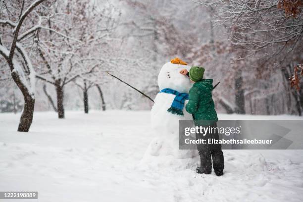 boy standing in the forest making a snowman, usa - making a snowman stock pictures, royalty-free photos & images