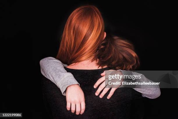 rear view of a woman hugging her son - sad mom stock pictures, royalty-free photos & images