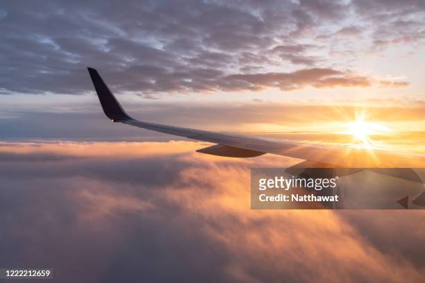 view from the airplane with the sun rising over the horizon - flugzeug fenster stock-fotos und bilder