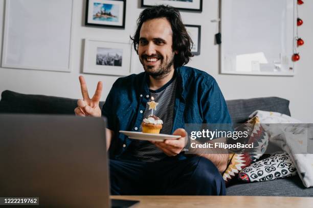 man is celebrating his birthday "virtually" with his friends and relatives with a voip call - zoom birthday stock pictures, royalty-free photos & images
