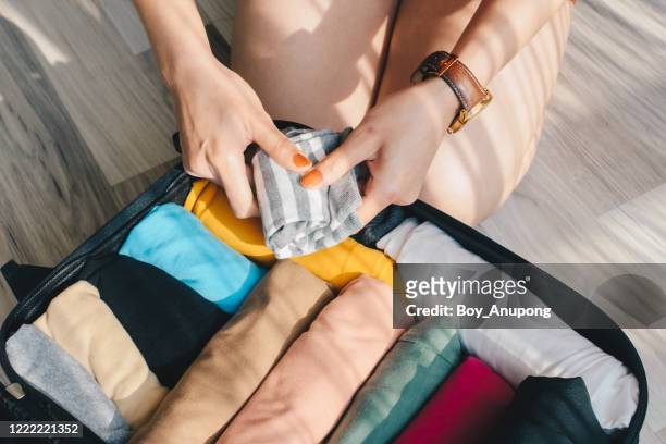 close-up of tourist woman open suitcase roll and pack colorful cloths for travelling. - rolling fotografías e imágenes de stock