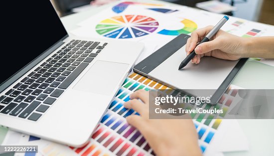 Graphic designer at work. Color swatch samples. Artist drawing something on graphic tablet at the office. Graphic designer creativity editor ideas designer concept Graphic designer at work. Color swatch samples. Artist drawing something on graphic tablet at the office. Graphic designer creativity editor ideas designer concept