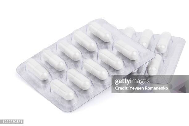 white pills in a blister pack on white background - schmerzmittel stock-fotos und bilder