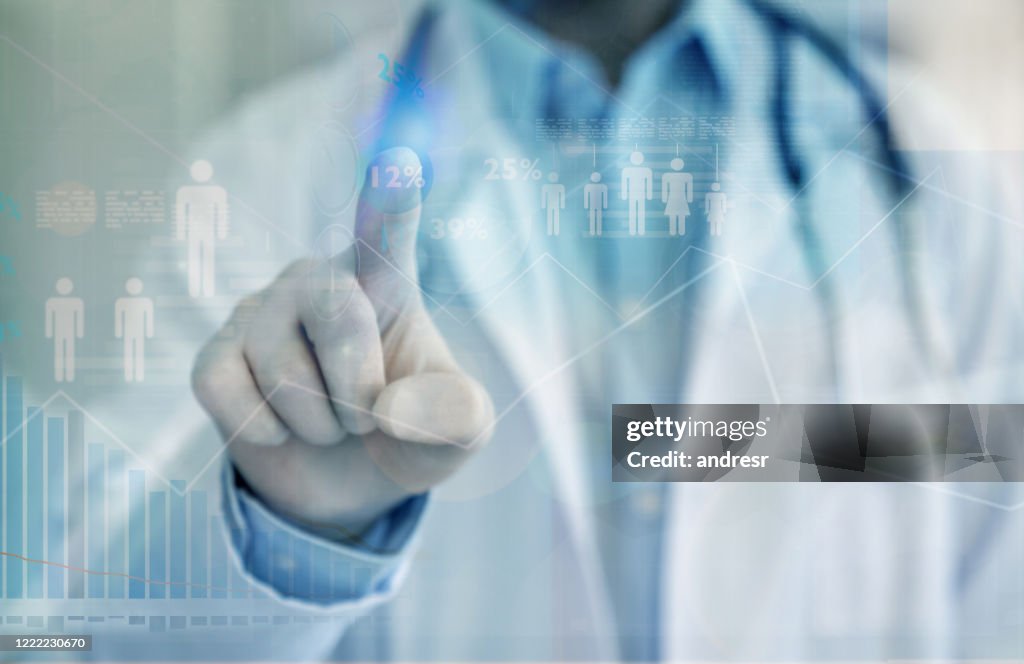 Research doctor pointing on a screen while looking at data on an infectious disease