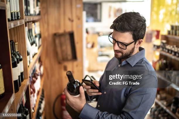 mid adult man customer buying using mobile phone at store - scanner stock stock pictures, royalty-free photos & images