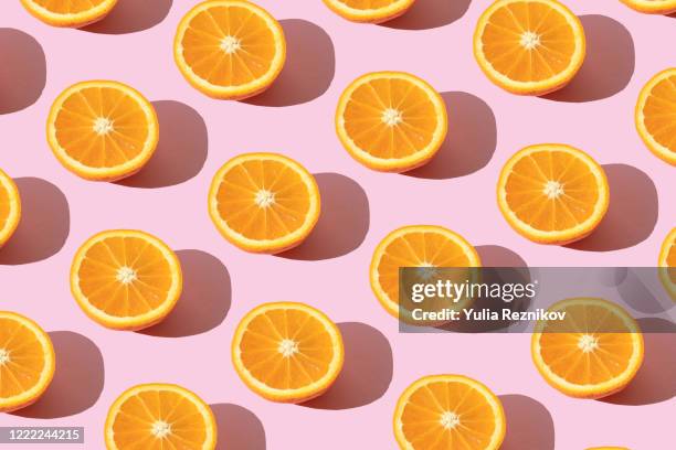 repeated orange on the pink background - orange fruit ストックフォトと画像