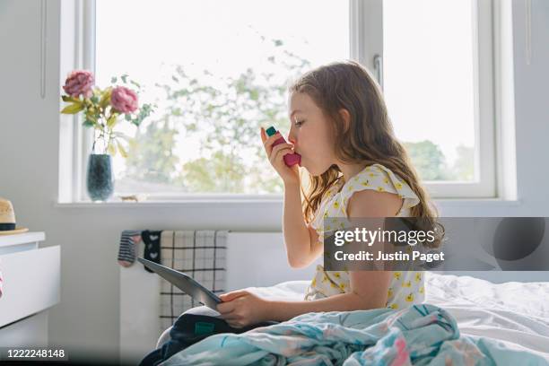 young girl with pink asthma inhaler - asthmainhalator stock-fotos und bilder