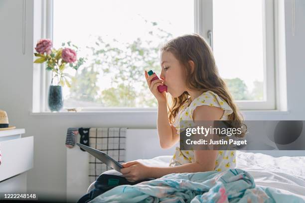 young girl with pink asthma inhaler - asthmatic stock pictures, royalty-free photos & images