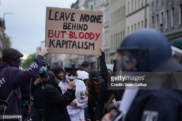Activists protest against capitalism as riot police stand nearby during scattered left-wing protests in Kreuzberg district on May Day during the...
