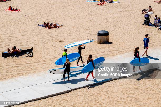 Surfers enjoying the sun and the warm weather during the heat wave at a beach in the Scheveningen district.