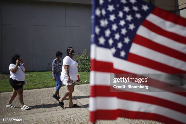 Voters wearing protective masks arrive outside a polling location in Louisville, Kentucky, U.S., on Tuesday, June 23, 2020. Counties today opened...