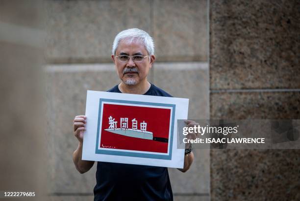 This picture taken on June 20, 2020 shows political cartoonist Wong Kei-kwan, one of the city's most prominent cartoonists, holding one of his...