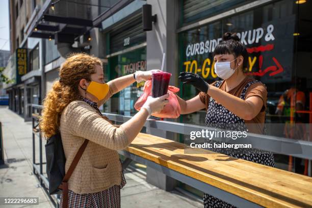 woman wearing homemade mask picks up food at restaurant during covid-19 lockdown - covid 19 food stock pictures, royalty-free photos & images