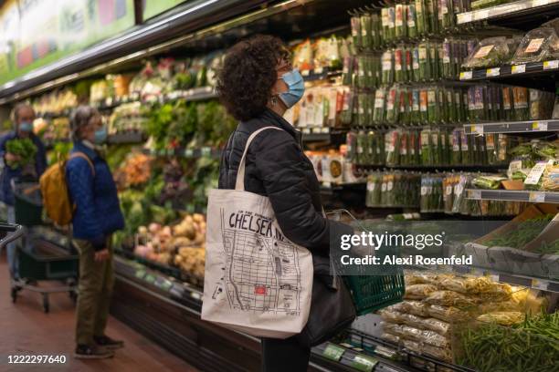 Woman wearing a mask and gloves shops at Fairway supermarket amid the coronavirus pandemic on May 1, 2020 in New York City, United States. COVID-19...
