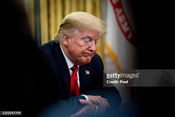 President Donald Trump sits a the Resolute Desk while announcing that the Food and Drug Administration issued an emergency approval for the antiviral...
