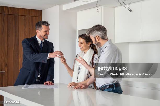real estate agent giving house keys to couple - recived stock pictures, royalty-free photos & images