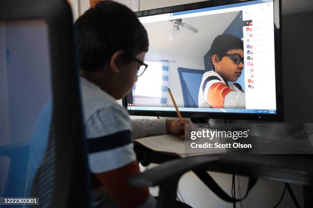 Seven-year-old Hamza Haqqani, a 2nd grade student at Al-Huda Academy, uses a computer to participate in an E-learning class with his teacher and...