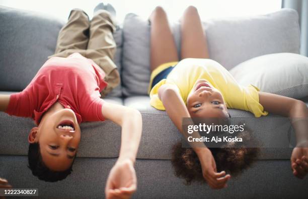 children lying down on the sofa at home. - lying on back girl on the sofa stock pictures, royalty-free photos & images