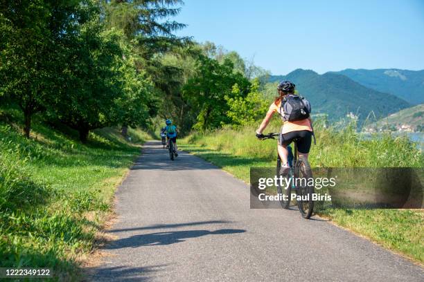 mother and son are cycling  by the danube river, wachau, austria - fahrradweg stock-fotos und bilder