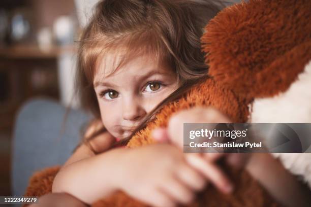 portrait of girl smiling, huging his soft toy fox - stofftier stock-fotos und bilder