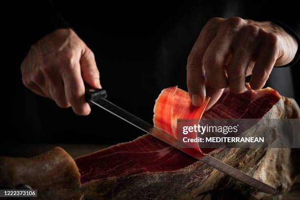 iberian ham serrano ham slice cutting hands and knife - jamón serrano stock pictures, royalty-free photos & images