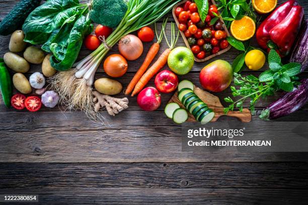 fruits and vegetables vegetarian food on rustic wood board - vegetable stock pictures, royalty-free photos & images