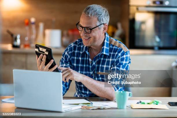 businessman checking the profitability of investments into cryptocurrencies - plaid shirt stock pictures, royalty-free photos & images