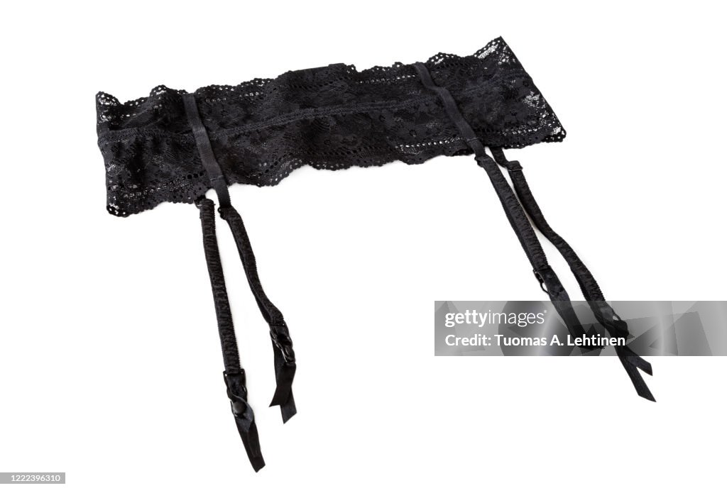 Close-up of a sexy black lacy garter or suspender belt, isolated on white background.