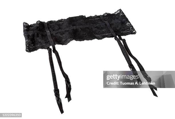 close-up of a sexy black lacy garter or suspender belt, isolated on white background. - black belt fashion item stock pictures, royalty-free photos & images