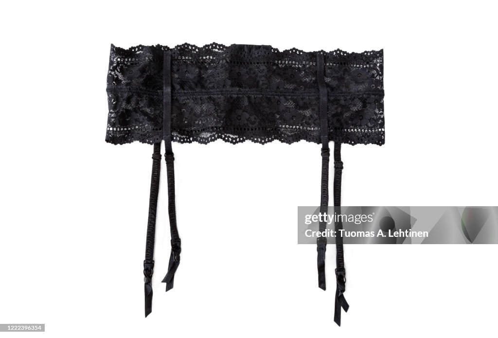 Close-up of a sexy black lacy garter or suspender belt, isolated on white background.
