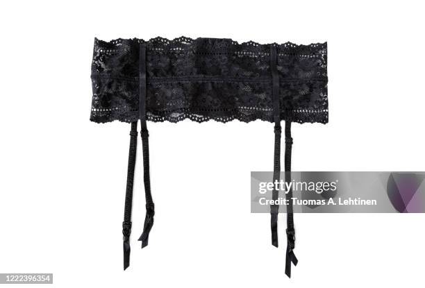 close-up of a sexy black lacy garter or suspender belt, isolated on white background. - black belt fashion item stock pictures, royalty-free photos & images