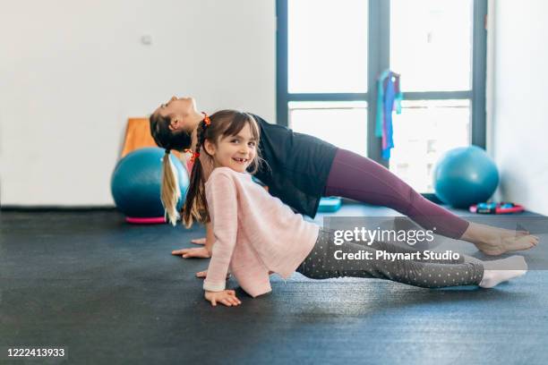 mittlere erwachsene mutter üben yoga mit ihrer tochter, schöne mutter und tochter training yoga-training - kids gymnastics stock-fotos und bilder
